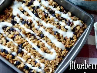 A quick and easy Blueberry Oat Breakfast Bars recipe that your kids will go crazy for. A wonderful on-the-go breakfast option that's packed with fresh blueberries, organic rolls oats, baked, and then drizzled with a tangy yogurt glaze.