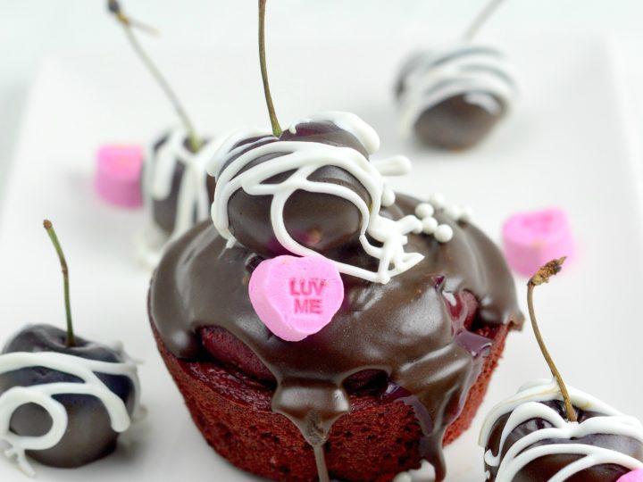 Cherry Valentines Day Cupcakes. A Red Velvet Cupcake filled with a delicious from scratch Cherry Sauce. Topped with Chocolate Ganache and chocolate dipped cherries.