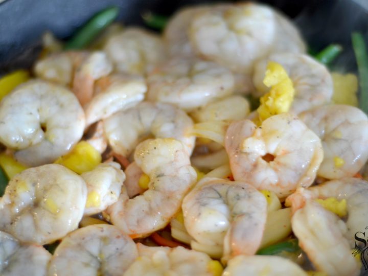 A homemade Pineapple Fried Rice featuring freshly made steamed rice with pineapple juice, fresh vegetables, pineapple chunks, and tiger shrimp. This easy pineapple fried rice recipe is served in a sweet and savory fried rice dish that is better than takeout.