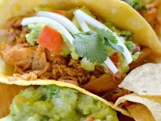 A tasty Chicken Tacos with a Homemade Guacamole recipe, featuring fresh toppings and a side of tortilla chips. Make this easy chicken taco and homemade guacamole recipe for the perfect taco Tuesday dinner.
