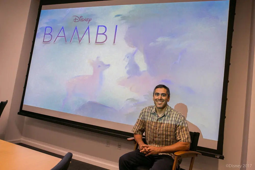 Photo of Paul Felix sitting in front of a screen with the movie Bambi in the background during Exclusive Interview With The Voices of Disney's Bambi and Thumper.