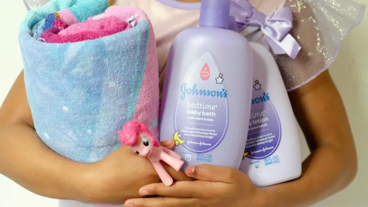 Create your very own Bathtime Travel kit with my checklist. Little african american girl holding her bathtime travel kit essentials.