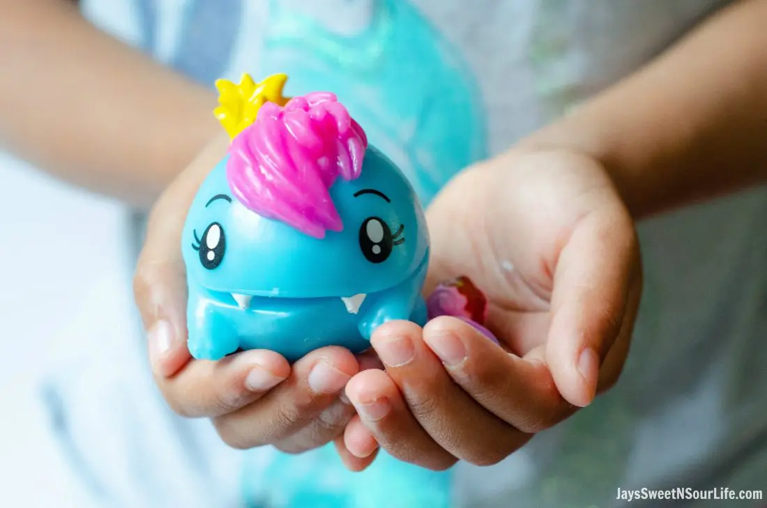 African American girl holding Pooparoos squishy toy in her hand. Pooparoos are full of fun surprises and tons of fun for all.