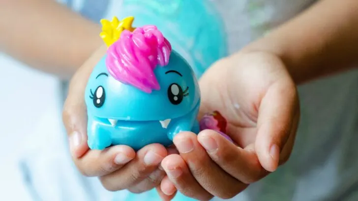 African American girl holding Pooparoos squishy toy in her hand. Pooparoos are full of fun surprises and tons of fun for all.
