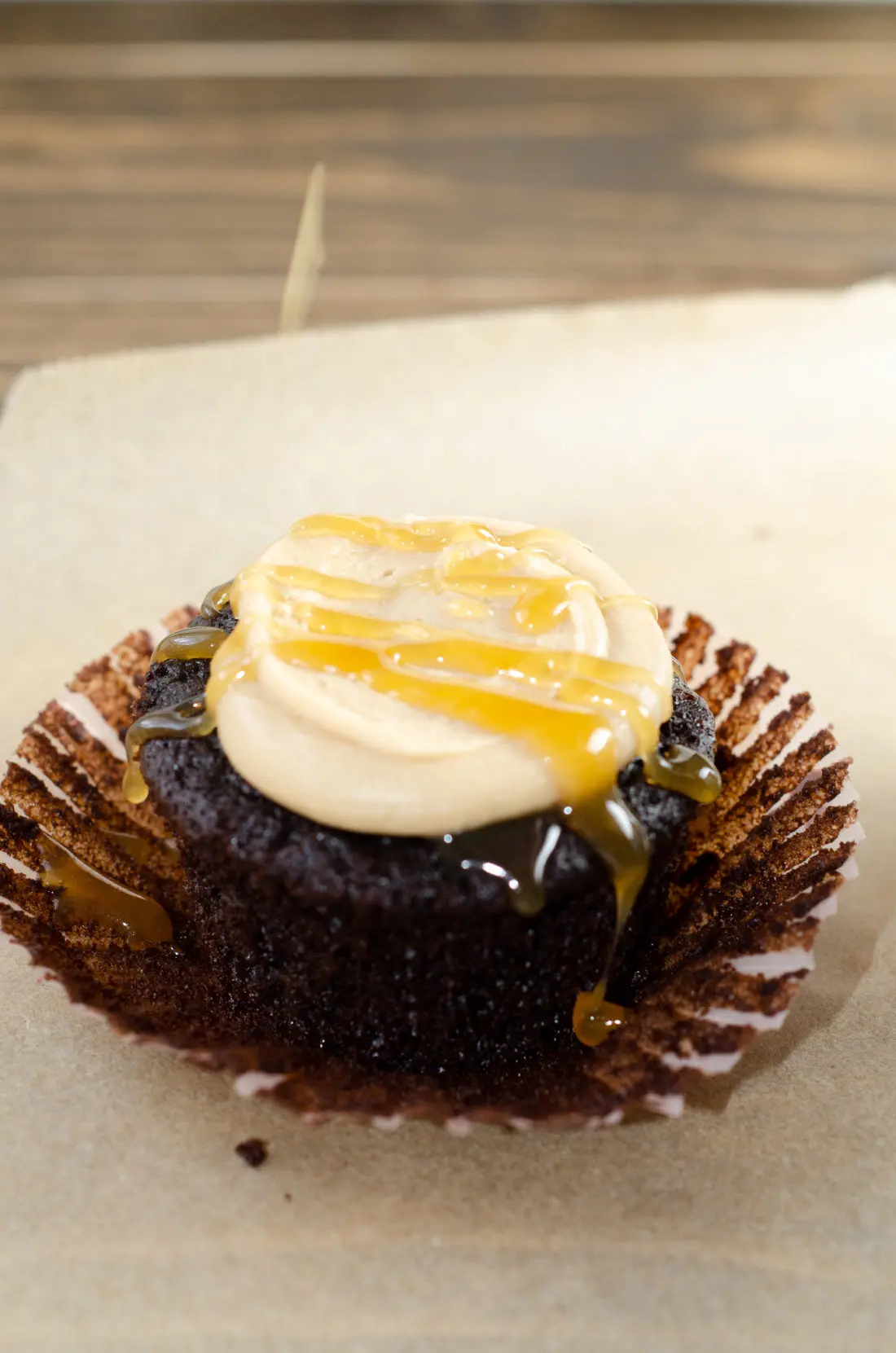 Super Moist Chocolate Cupcakes From Scratch Salted Caramel Frosting Drizilled with caramel closeup. Celebrate any occasion with these decadent Super Moist Chocolate Cupcakes From Scratch with Salted Caramel Frosting and Caramel Filled Center. This homemade recipe is so easy to create, the kids can join in.