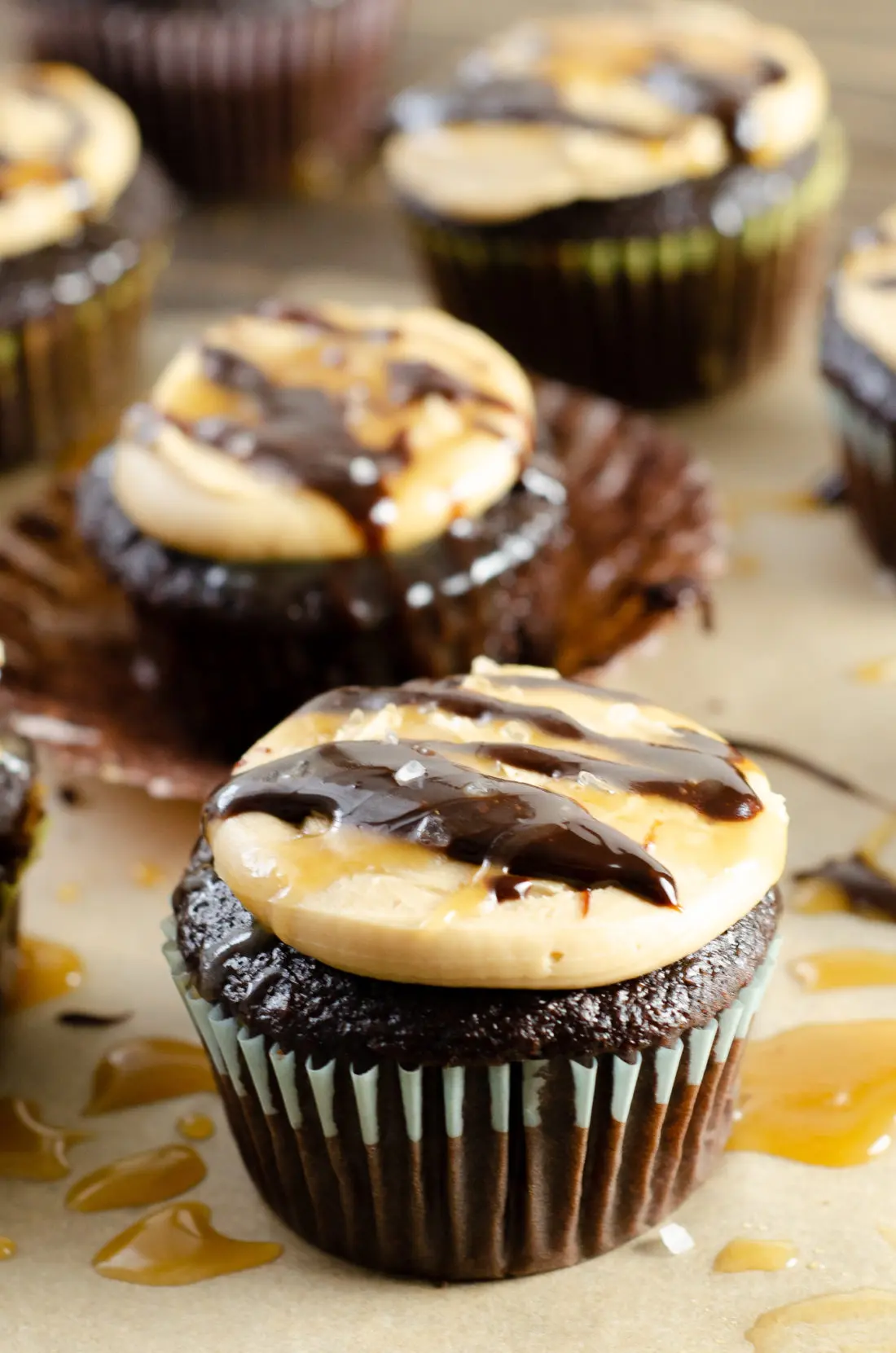 Super Moist Chocolate Cupcakes From Scratch Salted Caramel Frosting Drizilled with caramel and chocolate fudge closeup. Celebrate any occasion with these decadent Super Moist Chocolate Cupcakes From Scratch with Salted Caramel Frosting and Caramel Filled Center. This homemade recipe is so easy to create, the kids can join in.
