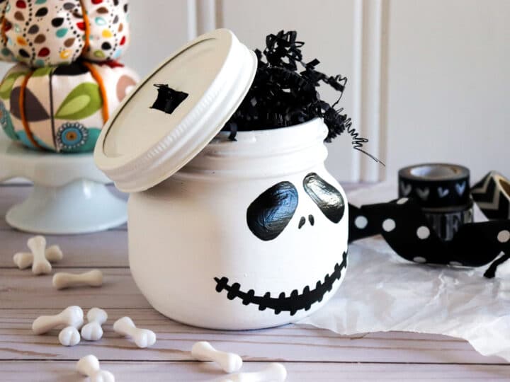 Jack Skellington Mason Jar Side View. This Jack Skellington Mason Jar Halloween Craft is the perfect way to creep your way into the Halloween season. Fill it with your favorite candies and treats, it's the perfect Halloween Craft that you can keep or gift.