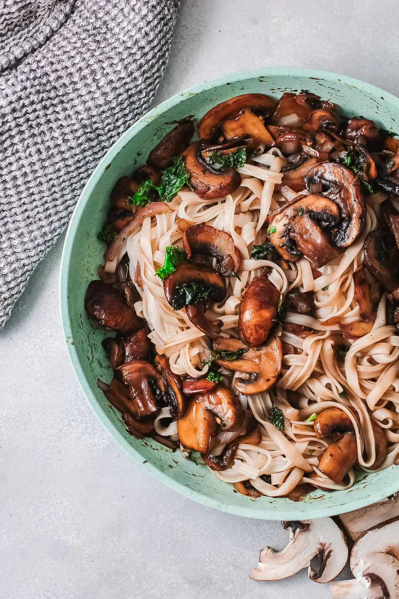 Vegetarian Korean Noodle Pan Closeup. This simple and easy Vegetarian Korean Noodles dish is full of flavor and can be made in under 30 minutes. The Korean noodles are stir-fried in a savory sauce made with fresh vegetables such as mushrooms, red onion, ginger, garlic, and kale.